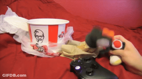 A Person Playing A Video Game Next To A Kfc Cup GIF