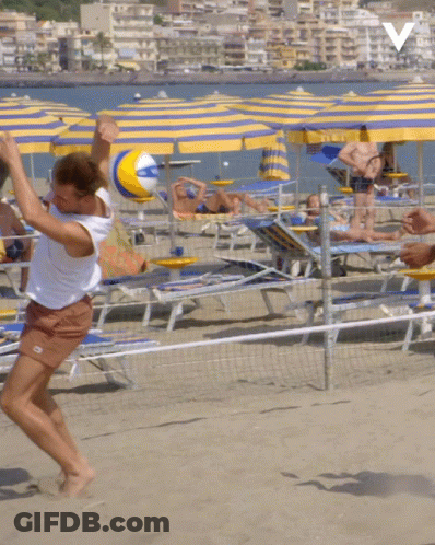 A Person Playing Volleyball On A Beach With A V On The Bottom GIF