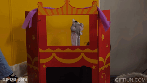 A Person Playing With A Puppet In A Puppet Theater With Gifrun.com Written On The Bottom Right GIF