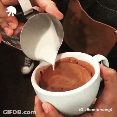 A Person Pouring Milk Into A Cup Of Coffee . GIF