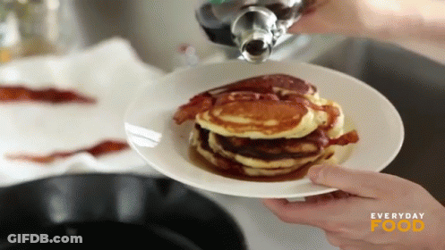 A Person Pouring Syrup On A Stack Of Pancakes With Everyday Food Written On The Bottom GIF
