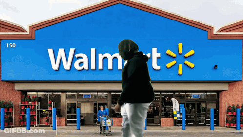 A Person Pushing A Shopping Cart In Front Of A Walmart GIF