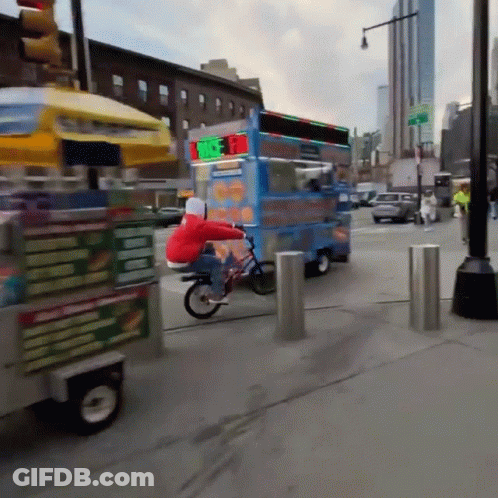 A Person Riding A Bike Next To A Food Truck That Says ' Ice Cream ' On The Side GIF