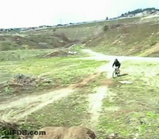 A Person Riding A Bike On A Dirt Road GIF