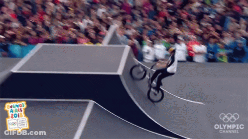 A Person Riding A Bike On A Ramp With The Olympic Channel Written On The Bottom GIF