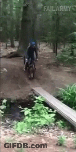 A Person Riding A Motorcycle In The Woods With Failarmy Written In The Corner GIF