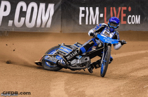 A Person Riding A Motorcycle On A Dirt Track With A P.com Sign In The Background GIF