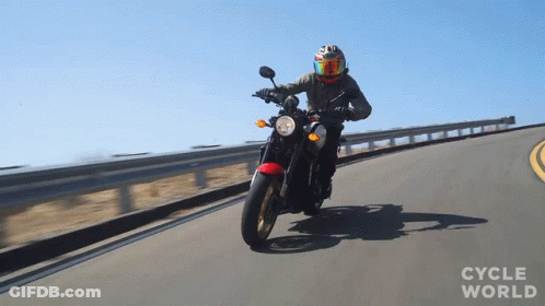 A Person Riding A Motorcycle On A Road With The Words Cycle World Visible GIF