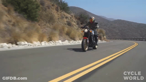 A Person Riding A Motorcycle On A Road With The Words Cycle World Written On The Bottom GIF