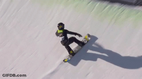 A Person Riding A Snowboard Down A Snowy Hill GIF