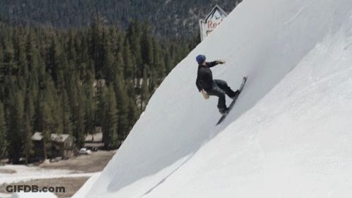 A Person Riding A Snowboard Down A Snowy Slope With A Red Bull Sign In The Background GIF