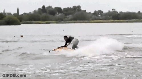 A Person Riding A Surfboard In The Water GIF