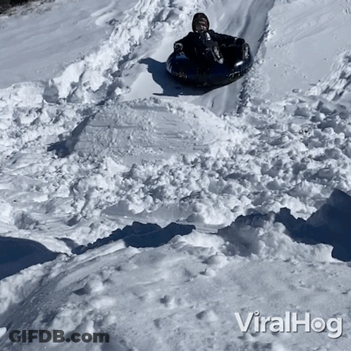 A Person Riding A Tube Down A Snowy Hill With The Words Viralhog On The Bottom Of The Image GIF