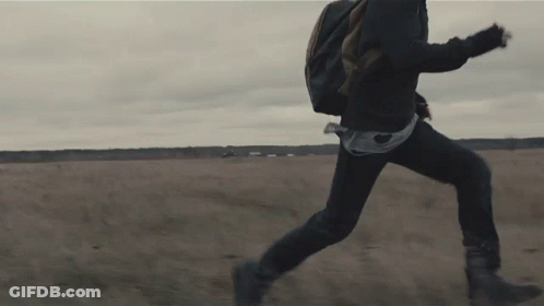 A Person Running In A Field With A Backpack On Their Back GIF