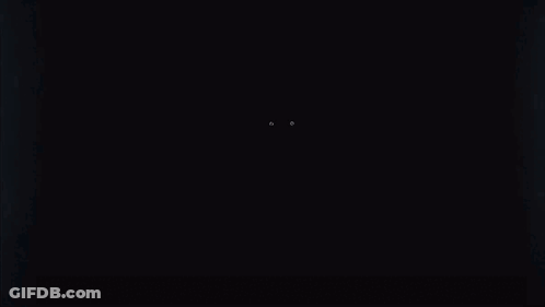 A Person 'S Eyes Are Glowing In The Dark In A Dark Room . GIF