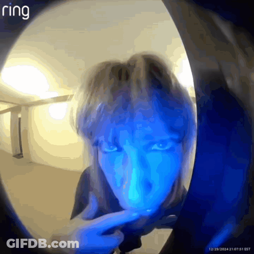 A Person 'S Face Is Visible Through A Doorbell With Ring Written On The Bottom GIF