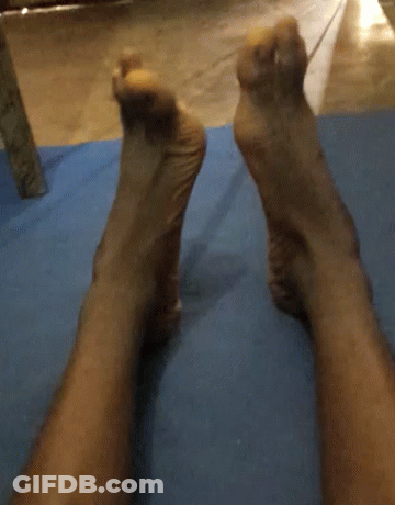 A Person 'S Feet Are Laying On A Blue Yoga Mat GIF
