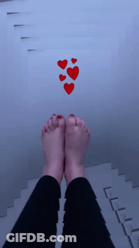 A Person 'S Feet Are Standing On A Staircase With Red Hearts Floating Above Them GIF