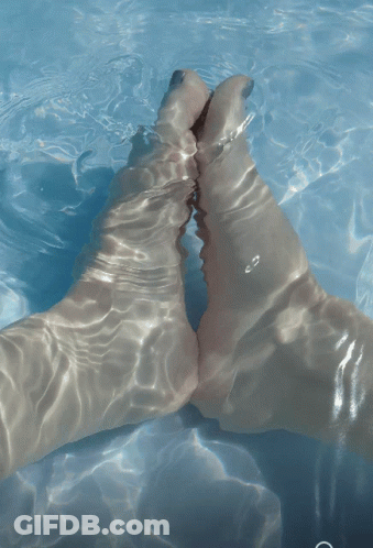 A Person 'S Feet Are Visible In The Water GIF