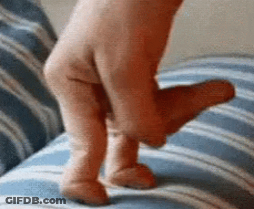 A Person 'S Foot Is Laying On A Blue And White Striped Couch . GIF