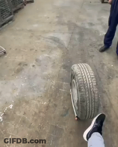 A Person 'S Foot Is On A Tire That Has A Black Stripe On It GIF