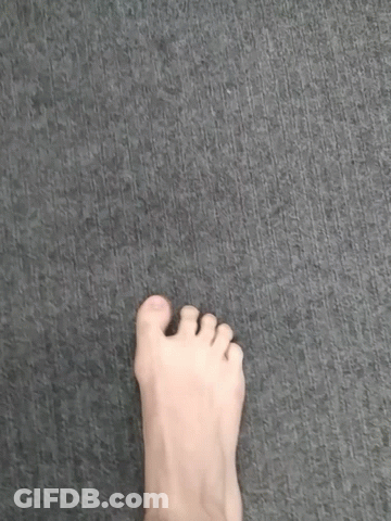 A Person 'S Foot Is Standing On A Gray Carpet . GIF
