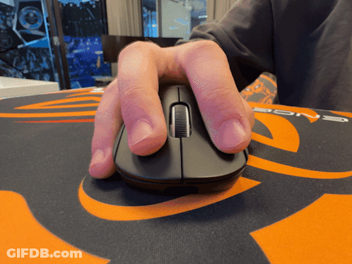 A Person 'S Hand Is Holding A Computer Mouse On An Orange And Black Mouse Pad GIF