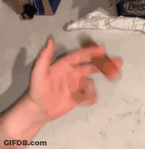A Person 'S Hand Is Holding A Piece Of Chocolate GIF