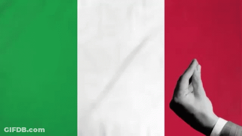 A Person 'S Hand Is Making A Heart Shape In Front Of A Flag Of Italy . GIF