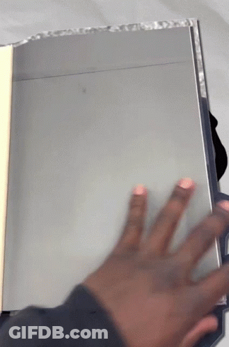 A Person 'S Hand Is Reaching Out Towards A Book GIF