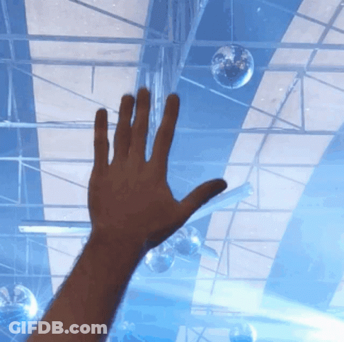 A Person 'S Hand Is Reaching Up Towards A Disco Ball GIF