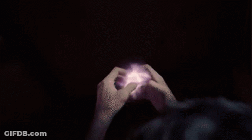 A Person 'S Hands Are Reaching Out Towards A Purple And Pink Circle GIF