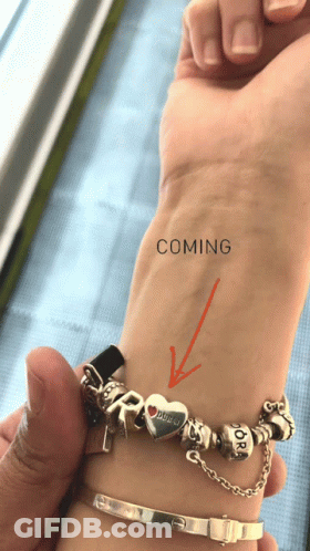 A Person 'S Wrist With An Arrow Pointing To The Word Coming On It GIF