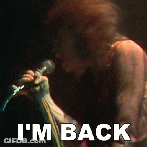 A Person Singing Into A Microphone With The Words I 'M Back Below Them GIF