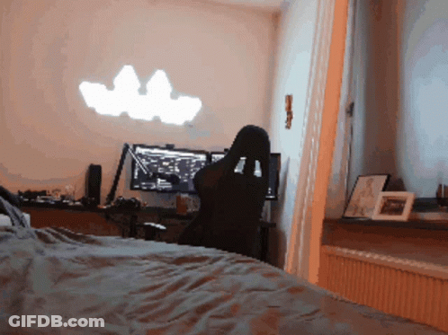 A Person Sits In A Chair In Front Of A Computer GIF
