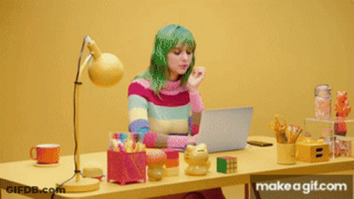 A Person Sitting At A Desk With A Laptop On It GIF