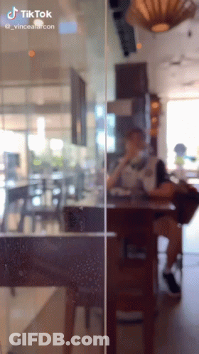A Person Sitting At A Table In A Restaurant With A Tiktok Watermark On The Bottom GIF