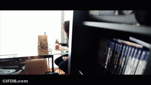 A Person Sitting At A Table With A Bag That Says ' A ' On It GIF
