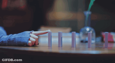 A Person Sitting At A Table With Their Finger Pointing GIF