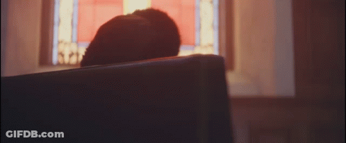 A Person Sitting In A Church Looking Out A Window GIF