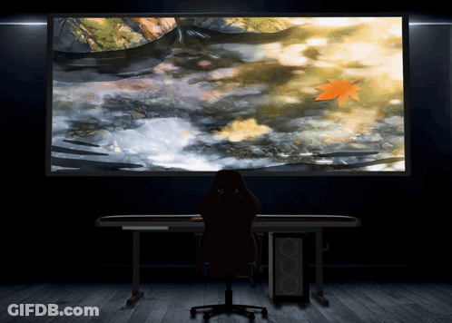 A Person Sitting In Front Of A Large Screen GIF