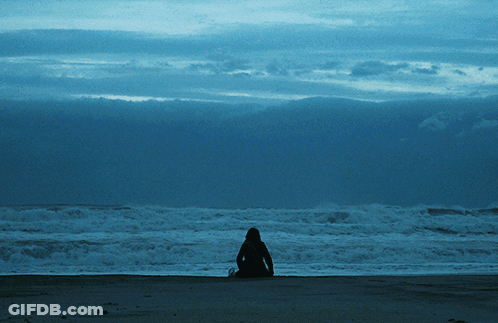 Person Sitting On Beach Looking At Ocean GIF