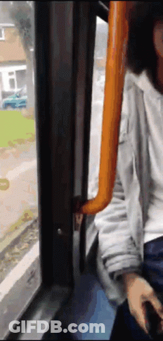 A Person Sitting On A Bus Looking Out Of A Window GIF