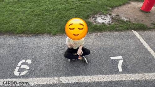 A Person Sitting On The Ground With A Smiley Face On Their Face And The Number 7 On The Ground GIF