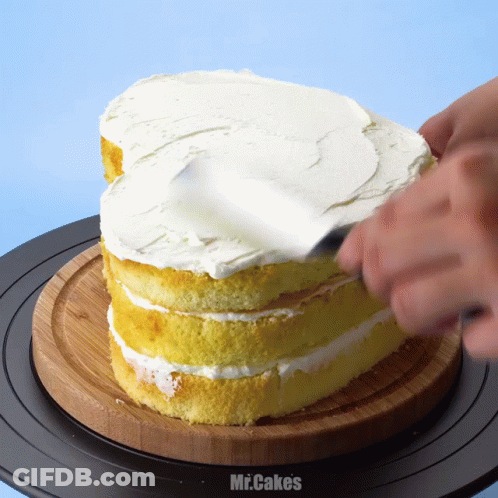 A Person Spreading Frosting On A Cake With The Words Mr.cakes Below It GIF