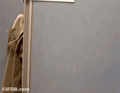 A Person Standing In A Cubicle With A Sign That Says ' News ' On It GIF