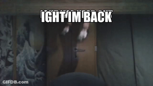 A Person Standing In Front Of A Door With The Words Ight I 'M Back Written Above Them GIF