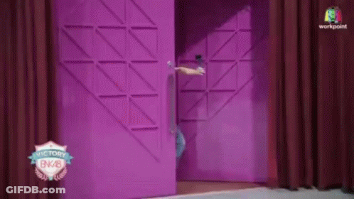 A Person Standing In Front Of A Pink Door That Says Victory Bnk28 GIF