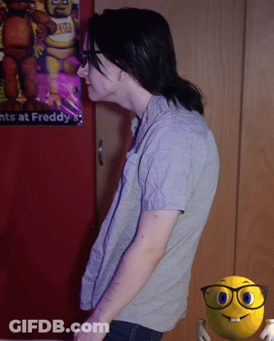 A Person Standing In Front Of A Poster That Says ' Nights At Freddy ' On It GIF