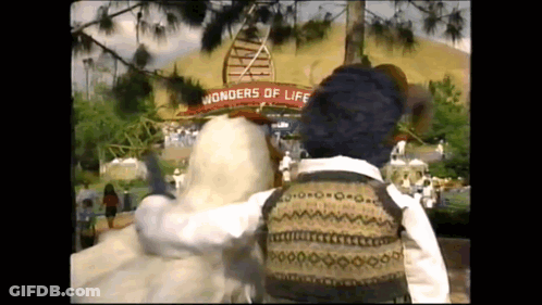 A Person Standing In Front Of A Sign That Says " Wonders Of Life " GIF